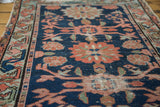 Distressed texture of antique Lilihan rug, navy field, salmon floral, and crab motifs.