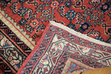 Hand-knotted Persian Engelas rug corner, highlighting tight weave and border in cherry red, lavender, and azure blue.