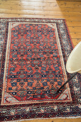 Vintage Persian Engelas rug close-up of cherry red field, geometric motifs, and azure, lavender border.