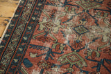 Distressed Lilihan rug detail showing faded cranberry field and celadon geometric motifs.