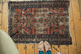 Distressed Lilihan rug with worn fringe, dark border, and faded cranberry geometric patterns.