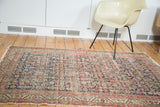 Distressed Antique Malayer rug with faded navy field, herati motif, and meandering serbend border.