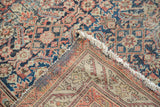 Distressed herati pattern, fringed edge, and hand-knotted foundation of an antique Malayer rug.