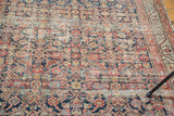 Distressed Herati motif in deep navy and terra cotta on a traditional Malayer rug.