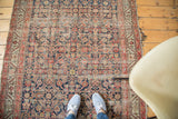 Distressed antique Malayer rug's navy herati motif, terra cotta serbend border, and wear.