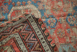Folded antique Soumac Caucasian rug detail, showing distressed flatweave, red and blue geometric motifs.