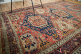 Distressed Soumac Caucasian rug with red, cobalt, and tangerine geometric motifs.