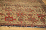 Antique Belouch rug's textured geometric pattern in ivory, fiery red, with navy fringe.