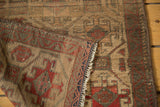 Aged pile and geometric patterns in red-orange, gold, and blue on antique Belouch rug's folded edge.