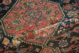 Distressed antique Bijar rug, visible hole and crimson, charcoal geometric patterns.