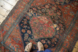 Angled detail of the distressed Halvaie Bijar, showing crimson red and navy blue patina.