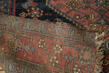 Distressed crimson red, navy Halvaie Bijar rug edge with worn pattern and fringe.