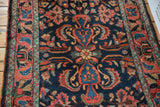 Saturated navy blue ground with elegant serrated leaves and vibrant floral motifs.