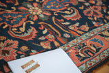 Hand-knotted vintage Borchalou rug showing navy ground, serrated leaves, and brick red border.