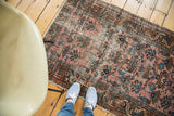 Distressed pile of the antique Lilihan rug showing faded raspberry field and softened blue motifs.