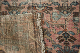 Faded raspberry blush Lilihan rug showing distressed pile, hand-knotted back, and fringe.