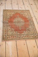 Angled perspective on a distressed antique Tabriz rug showing its even, time-softened wear.