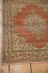 Detailed floral patterns in the ivory and brown border of a distressed antique Tabriz mat.