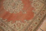 Detail of the soft, time-worn texture on a rust, ivory, and brown Tabriz rug corner.