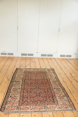 Angled view of antique Farahan Sarouk with faded terra cotta Herati field, expressive celadon border.