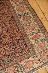 Detailed border of antique Farahan Sarouk rug with madder red lotus, celadon leaves, indigo field.