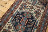 Indigo blue hexagonal medallion, serrated relief, and diverse floral motifs on an antique Hamadan rug.