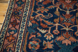Distressed antique Lilihan rug detail: navy blue field, rust, azure patterns, and patterned border.