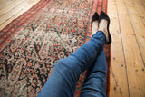 Distressed antique Malayer rug runner, allover paisley, dark field, cerulean and candy red tones.