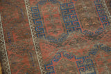 Distressed pile and tribal geometric patterns in cobalt blue and crimson red on an antique Belouch rug.