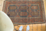 Distressed antique Belouch rug, featuring large geometric patterns in cobalt blue and crimson red.