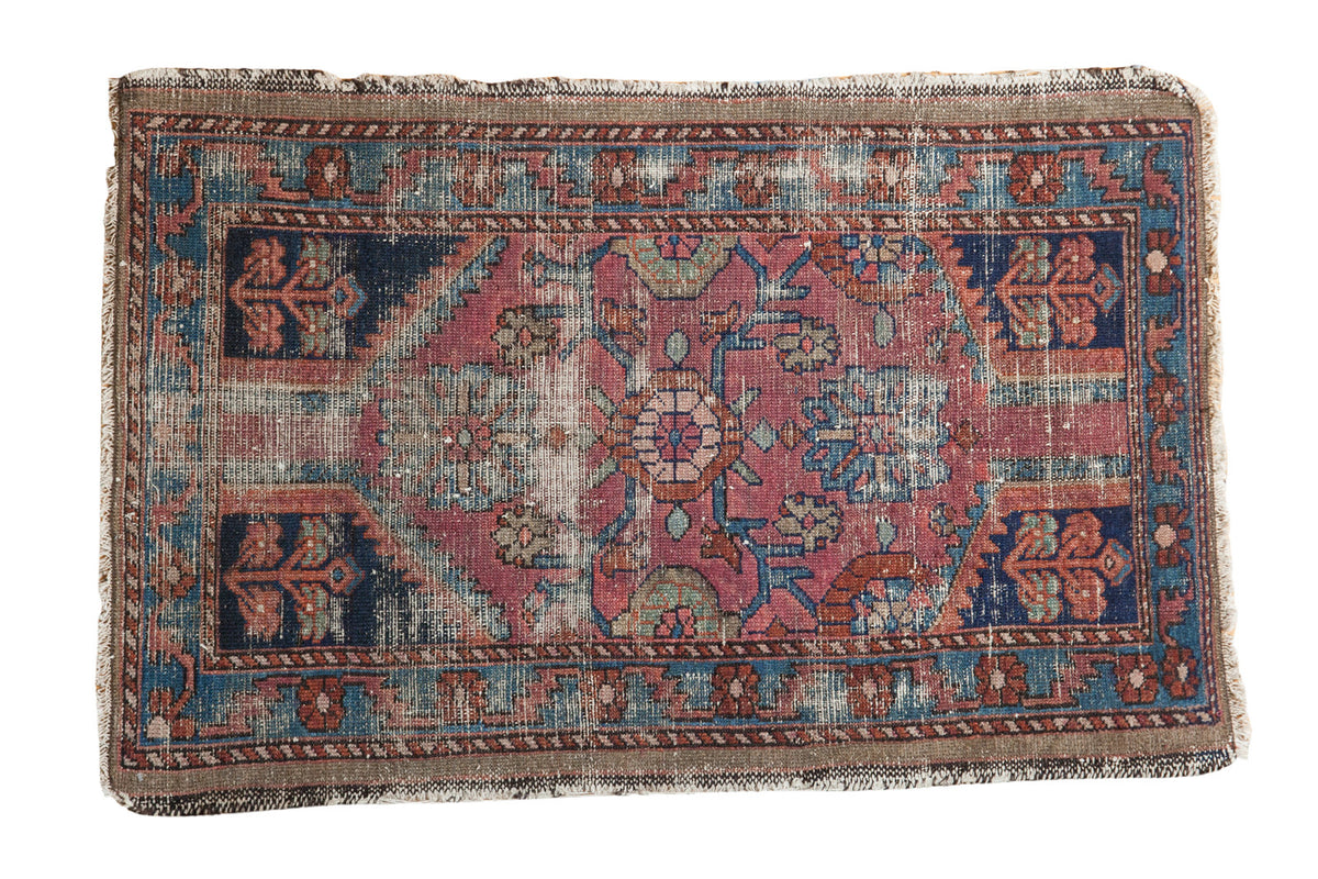 Distressed antique Lilihan rug, floral medallion in fuchsia, royal blue, and seafoam green.