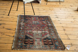 Distressed pile on an antique Lilihan rug, showing fuchsia, seafoam, and royal blue floral motifs.