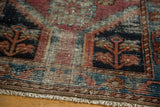 Distressed Lilihan rug border detail: fuchsia, royal blue, seafoam green floral geometric patterns, and fringe.