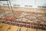 Traditional geometric border of a distressed antique Malayer runner in salmon, ivory, and brown.