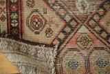Visible hand-knotted construction and distressed geometric animal motifs on antique Malayer rug.