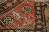 Finely distressed pile with geometric shapes and stylized animal motifs in warm salmon and brown tones.
