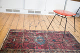Distressed texture and contrasting fuchsia, azure blue patterns on a vintage Lilihan rug corner.