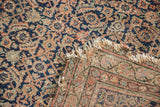 Distressed Malayer rug with heavy tatter on fringe, showing woven border detail.