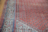 Distressed Mir Serbend rug: faded terra cotta field, arctic blue boteh motifs, patterned border.