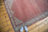 Distressed antique Mir Serbend rug corner, showing geometric borders, boteh field, and blue abrashes.