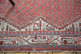 Decorative distressed antique Mir Serbend rug border with geometric shapes, terra cotta, and blue.