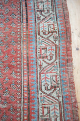 Faded terra cotta field meets geometric arctic blue border, highlighting the distressed edge.