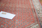 Antique Mir Serbend rug's faded terra cotta field, arctic blue boteh motif, and geometric border.
