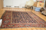 Antique Northwest Persian rug corner with indigo herati field and red samovar border.