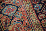 Detail of vibrant herati motifs and stylized samovar border on an antique Persian rug.