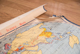 Detail of vintage world map showing the Pacific Ocean, Australia, and torn top edge.