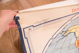 Hand holds vintage Denoyer Geppert map corner, showing 'A1' text and crease.