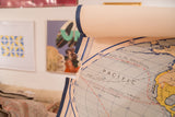 Vintage Denoyer Geppert world map, Pacific historical routes, light blue, cream, and torn edge.