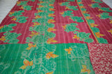 Hand-stitched Kantha quilt with vibrant red and green floral patterns and distinct patchwork.
