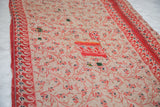Cream Kantha quilt with red vine pattern, dark blue flowers, and colorful patched details.